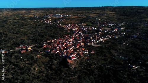 Long aerial zoom out of the village Villarino de los Aires, Spain , traditional white buildings with red slate roofs photo