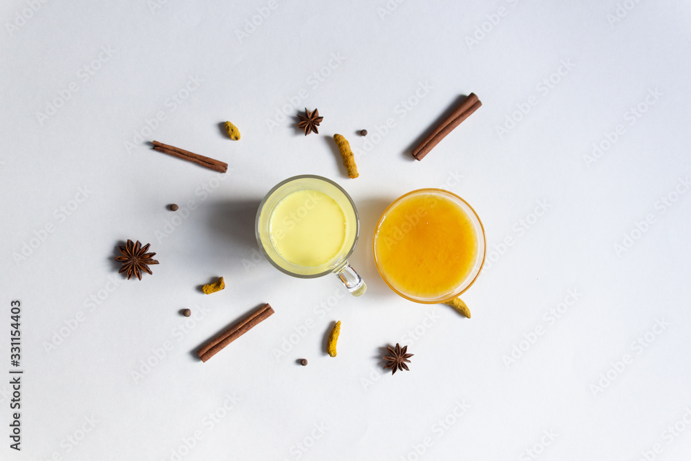 Golden milk with honey, turmeric, spices on white background Golden milk with honey, turmeric, spices on white background