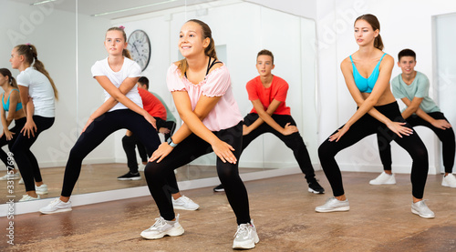 Teenage dancers practicing active vigorous dance in modern studio