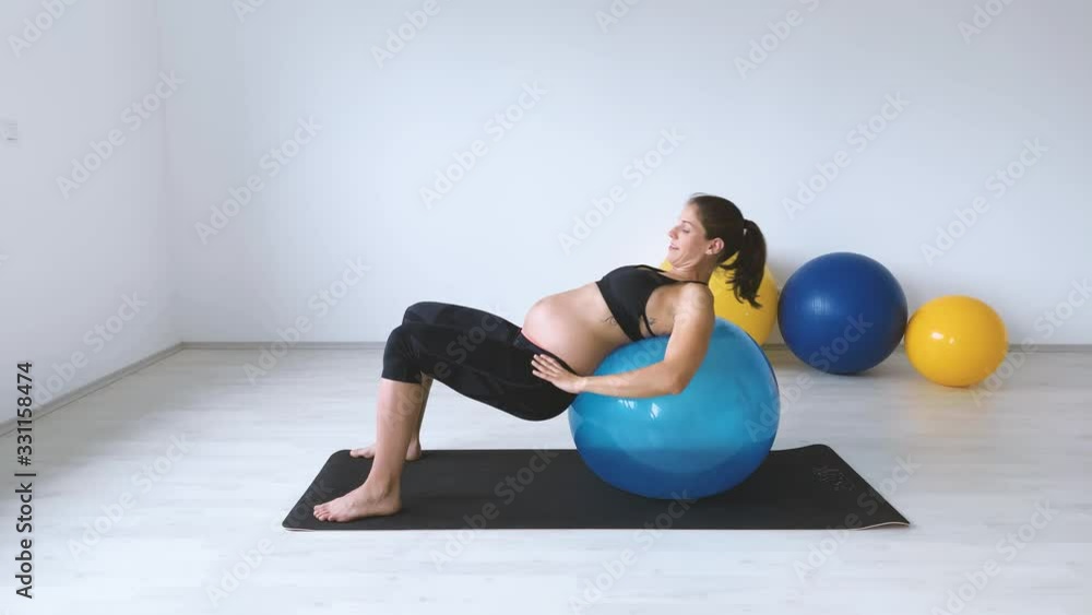 Slow motion shot of pregnant woman laying on exercise ball Slow motion shot of pregnant woman laying on exercise ball