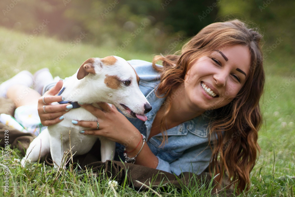Fototapeta premium Girl in the park plays with her dog, girl with her beloved pet