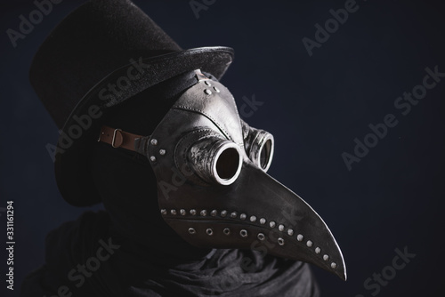 Masked man plague doctor, head profile, with bird mask and hat. Vintage style. Biohazard concept.