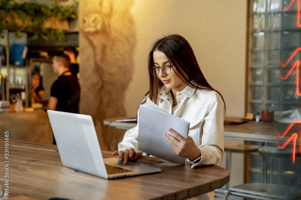 Attractive woman sitting at table and working on laptop Attractive woman sitting at table and working on laptop