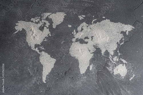 Fototapeta Naklejka Na Ścianę i Meble -  The contours of the map of the world from flour on a stone surface