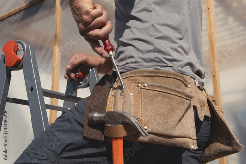 Close up tool belt with tools on construction worker at work.