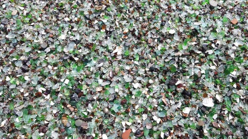 glass beach. many small fragments of glass carved by the sea lie on the beach. environmental pollution.