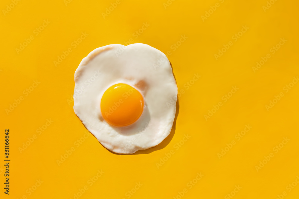 Fotografia Fried egg on yellow background