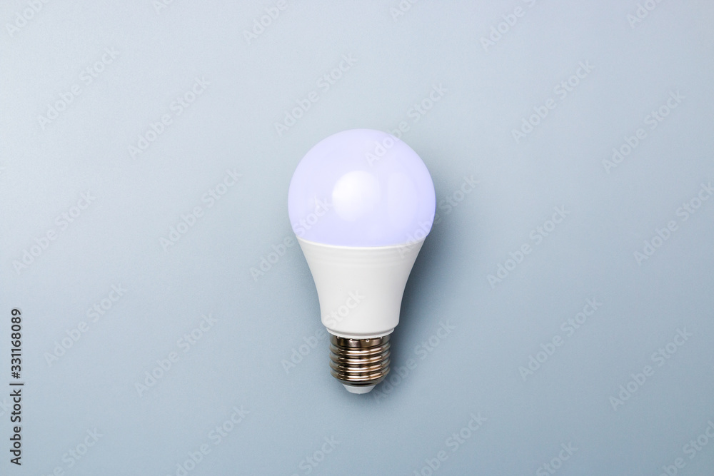 led bulb with purple light against a grey background with copy space. energy efficiency concept led bulb with purple light against a grey background with copy space. energy efficiency concept