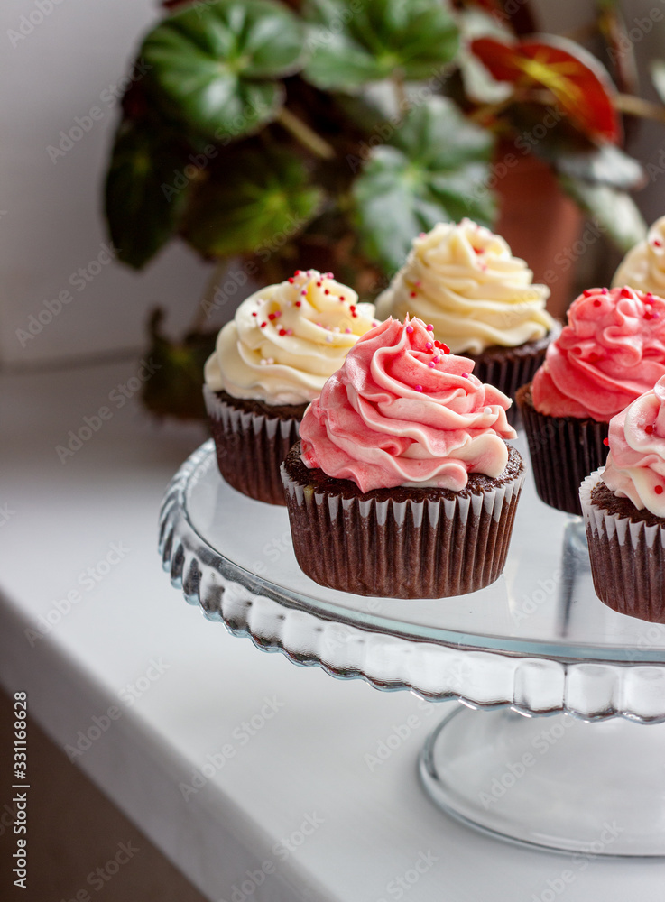 chocolate muffins with a hat of pink and white cream chocolate muffins with a hat of pink and white cream