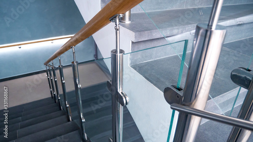 indoor staircase step with stainless steel and glass handrail.