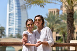 Happy mother with daughter posing in city