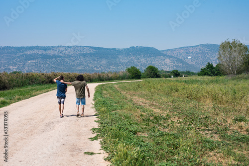 Long Shot Of Two Friends Walking In The Nature