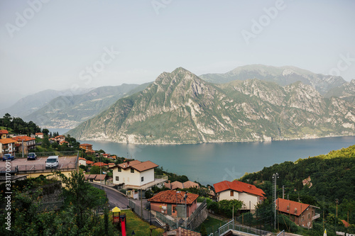 Summer sunny morning in the village near lake Iseo, Italy. Panorama view on Lago di Iseo, lake in Italy.