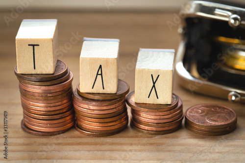 Wooden cubes with the word Tax on money climbing staits, pile of coins ,Tax Concept background photo