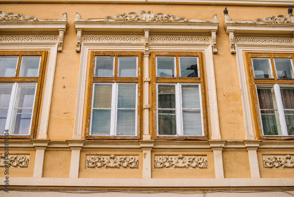 Brasov, Romania, 4 march 2020, photo of old beautiful windows on yellow wall