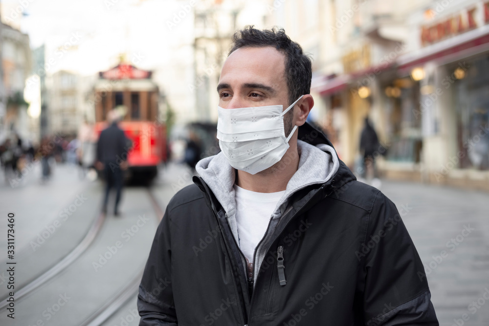 The adult man wanders the streets of Istanbul with a mask to prevent infectious diseases.
