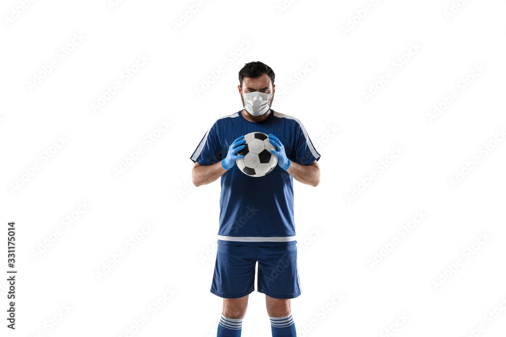 Obraz premium Punching virus. Football, soccer player in protective mask and gloves. Prevention against pneumonia. Still active while quarantine. Chinese coronavirus treatment. Healthcare, medicine, sport concept.