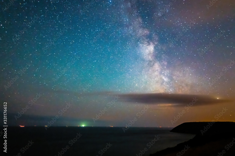Centre of the milky way galaxy over the sea behind a cloud