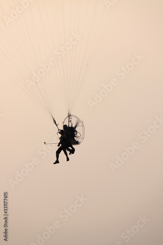 sport paraglider , helicopter in flight on blue sky 