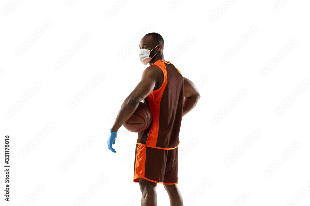 Beat it off. African-american basketball player in protective mask. Prevention against pneumonia. Still active while quarantine. Chinese coronavirus treatment. Healthcare, medicine, sport concept. Beat it off. African-american basketball player in protective mask. Prevention against pneumonia. Still active while quarantine. Chinese coronavirus treatment. Healthcare, medicine, sport concept.