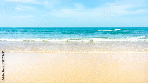 Clean white beach golden brown sand and small wave from blue sea under clear blue sky in a sunny day © Arunee