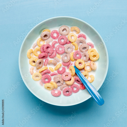 Colourful cereal in blue bowl and spoon