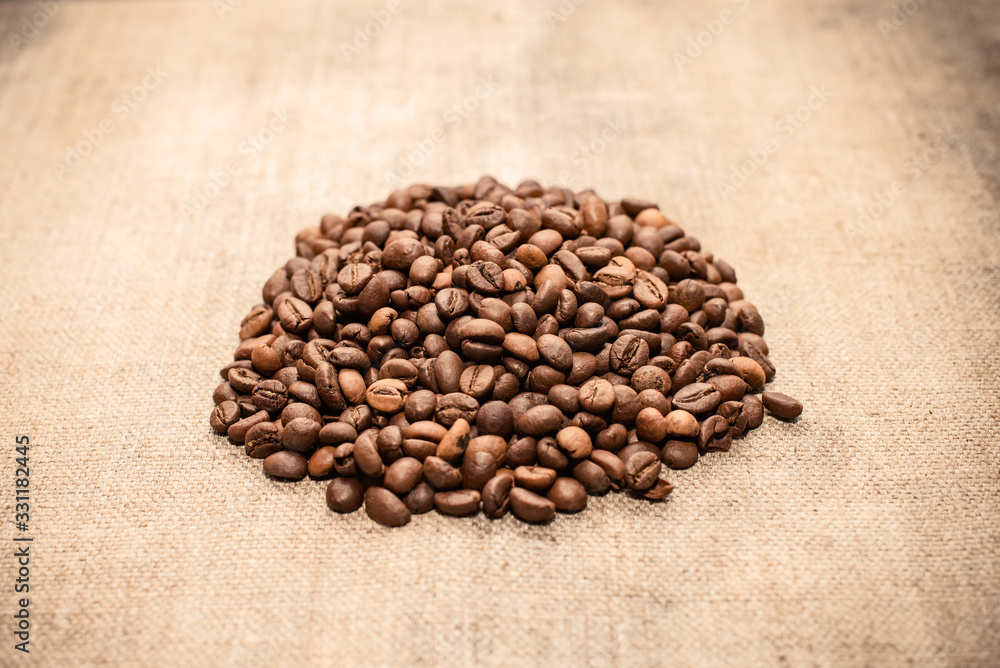 Coffee beans on a coarse cloth. Coffee beans in a pile Coffee beans on a coarse cloth. Coffee beans in a pile