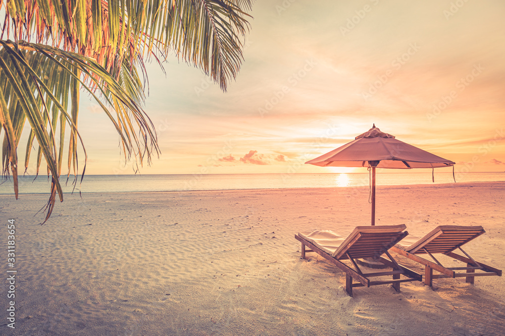 Relaxing sunset beach, summer vacation and holiday concept. Beach sunset view loungers and umbrella. Luxury travel landscape, exotic nature background. Paradise island view