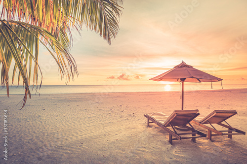 Relaxing sunset beach  summer vacation and holiday concept. Beach sunset view loungers and umbrella. Luxury travel landscape  exotic nature background. Paradise island view