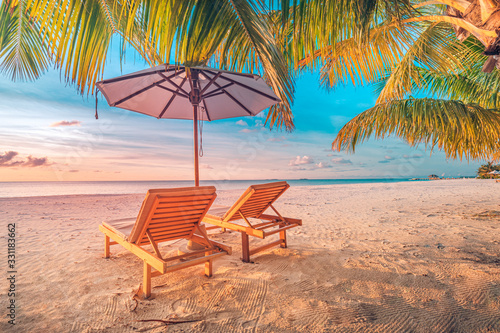 Relaxing sunset beach, summer vacation and holiday concept. Beach sunset view loungers and umbrella. Luxury travel landscape, exotic nature background. Paradise island view