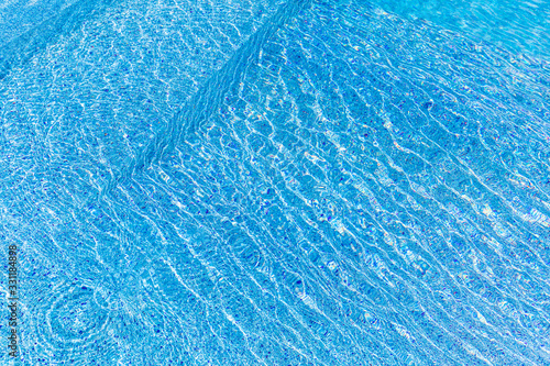 Blue swimming pool edge with refection of water ripple background. Luxury lifestyle and leisure concept