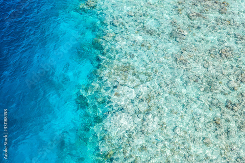 Amazing tropical nature. Aerial view of the tropical sea surface with coral reefs on the bottom