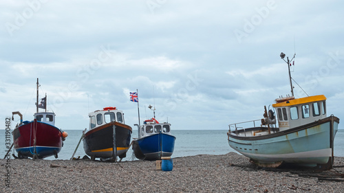 Foto Part of the local fishing fleet stranded on the pebble beach at Beer in south Devon, UK