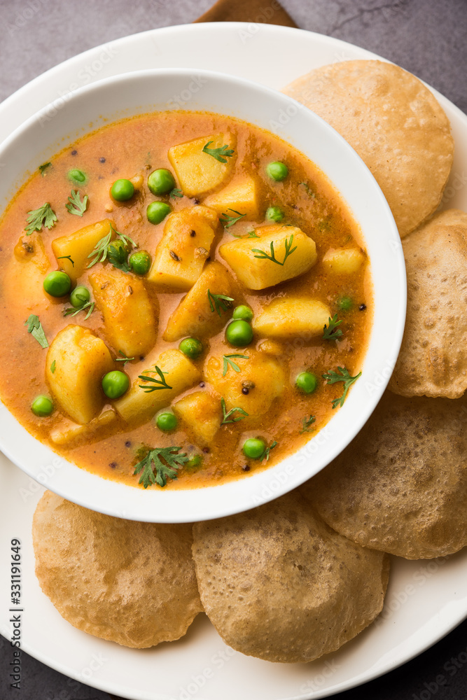 Aloo Puri or Potato curry with fried Poori, popular Indian breakfast / lunch / dinner menu. Aloo Puri or Potato curry with fried Poori, popular Indian breakfast / lunch / dinner menu.