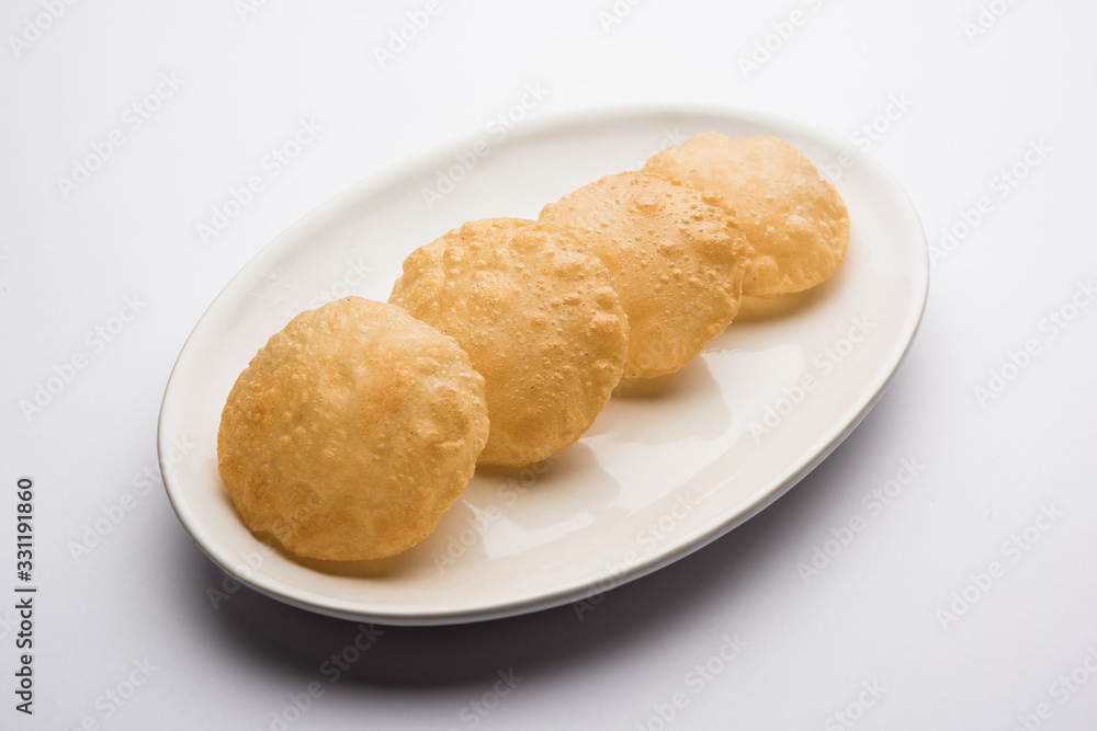 Plain Puri served in a plate. It's an Indian deep-fried bread made from whole-wheat flour, popular main course or breakfast recipe Plain Puri served in a plate. It's an Indian deep-fried bread made from whole-wheat flour, popular main course or breakfast recipe