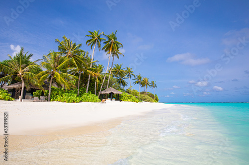 Beautiful beach and tropical sea. Luxury travel and vacation destination. Palm trees beach hut or bungalow on white sand, amazing summer mood. Peaceful tropical landscape view