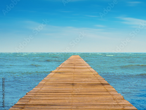 Scenery of wooden walkway  blue sea  cloudy skies