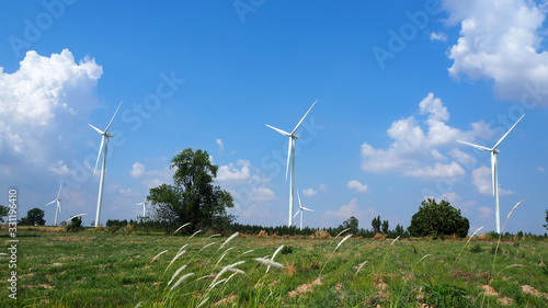 wind turbine and agricultural field with blue sky and white clouds for energy saving concept, landscaping shot photo.