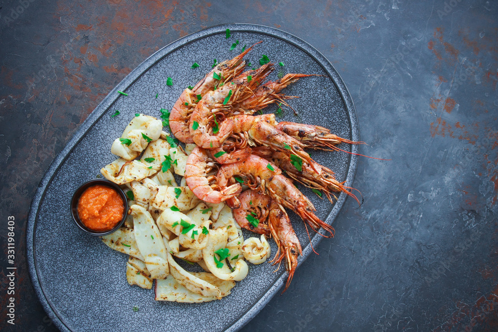 Plate with seafood, King prawns and squid, Fish menu in the restaurant, Dark background