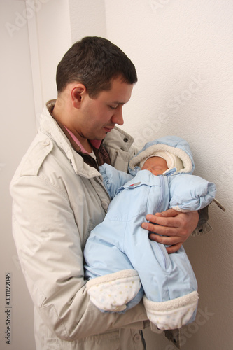 Happy father holds his newborn son in his arms. Isolated on white