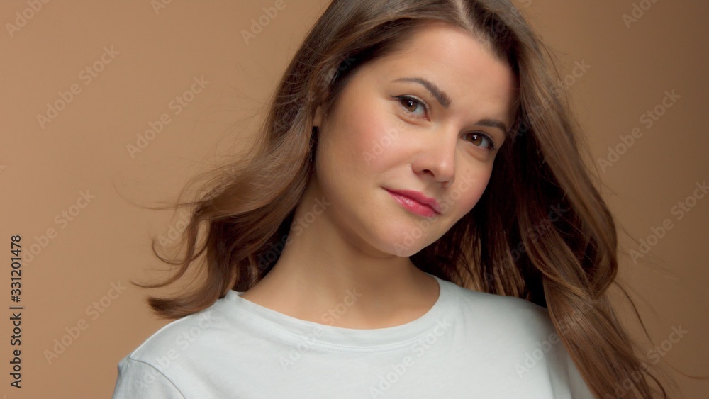 Monochrome natural makeup look Caucasian woman in studio in white t-shirtwith healthy shiny hair blowing With head slightly tilted Monochrome natural makeup look Caucasian woman in studio in white t-shirtwith healthy shiny hair blowing With head slightly tilted