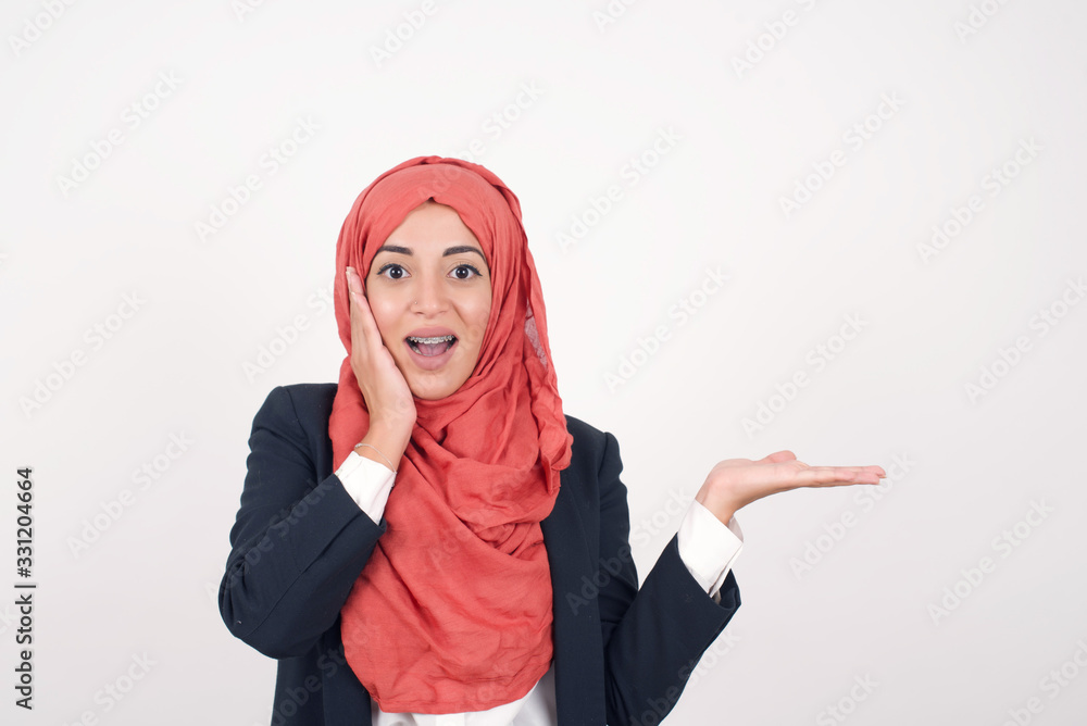 Shot of happy young woman with positive smile, has long hair, rejoices having weekend and good rest after hard working exhausting week, isolated on gray wall. Shot of happy young woman with positive smile, has long hair, rejoices having weekend and good rest after hard working exhausting week, isolated on gray wall.