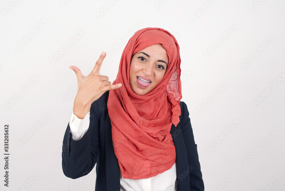 Portrait of a crazy girl showing tongue horns up gesture, expressing excitement of being on concert of band. Portrait of a crazy girl showing tongue horns up gesture, expressing excitement of being on concert of band.