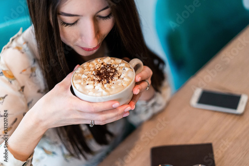 girl in a cafe at a table with coffee and a notebook