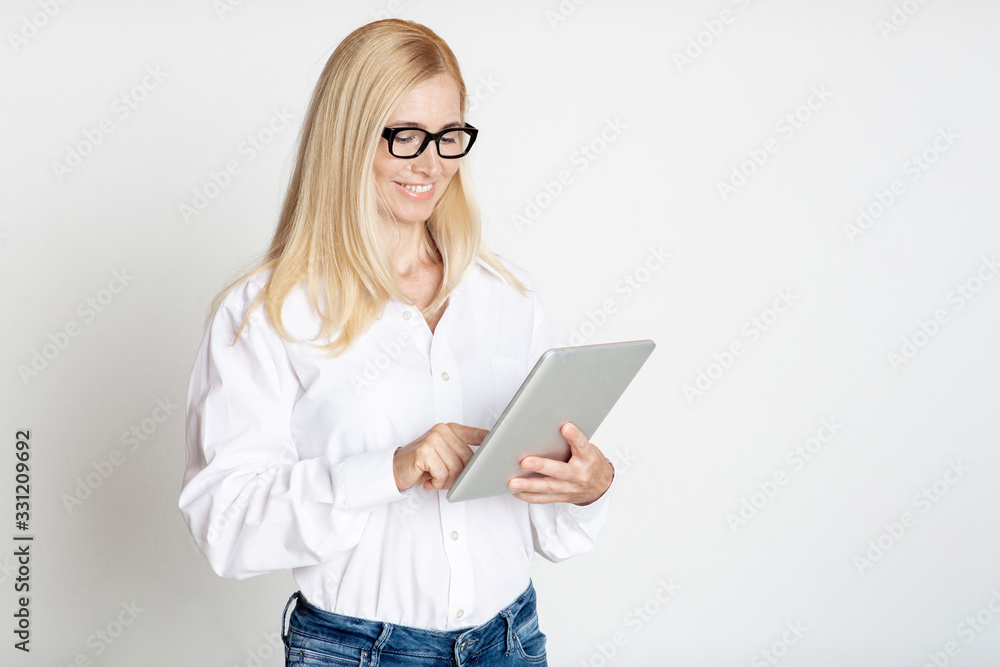 Mature Businesswoman Using Tablet In Modern Studio Mature Businesswoman Using Tablet In Modern Studio