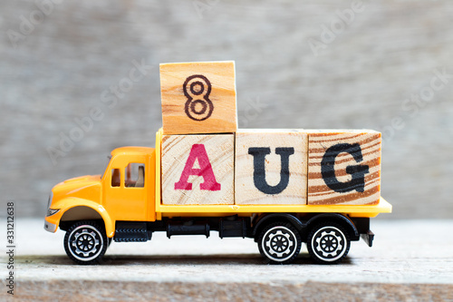 Truck hold letter block in word 8aug on wood background (Concept for date 8 month August) photo