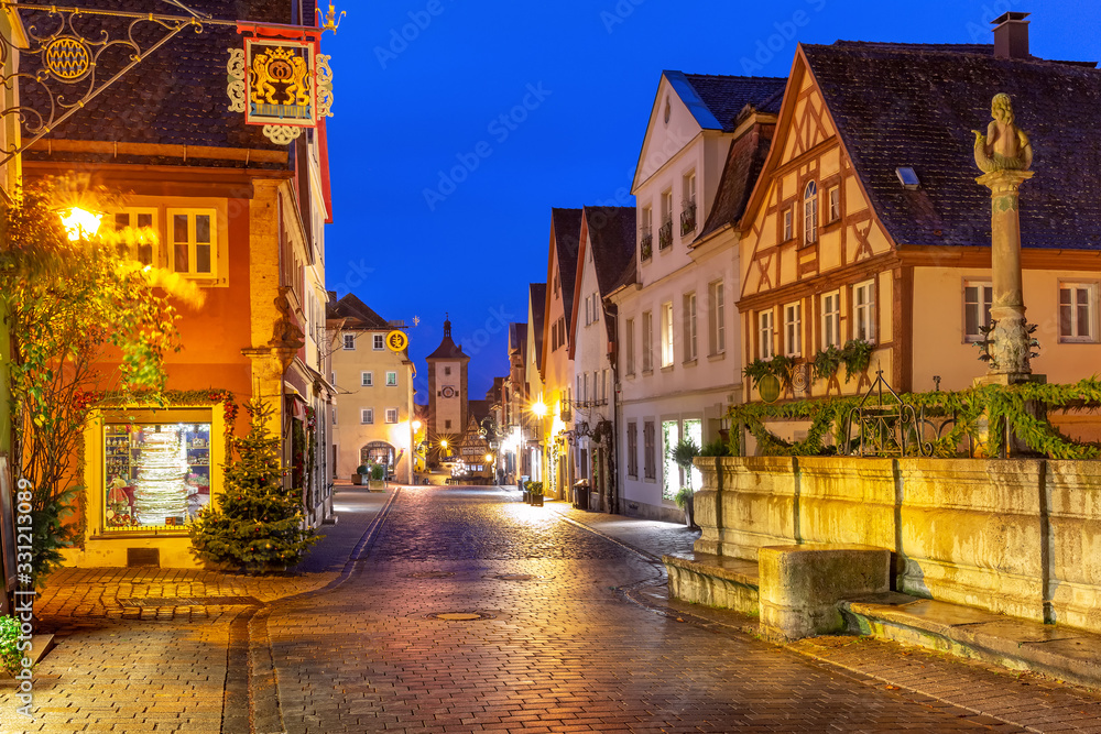Decorated and illuminated Christmas street with gate and tower Plonlein in medieval Old Town of Rothenburg ob der Tauber, Bavaria, southern Germany