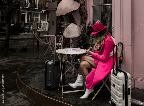 Women wearing pink coat and pink hat at a cafe in London