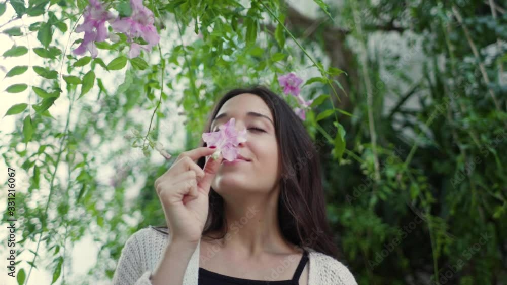 Young woman smelling on pink flower Young woman smelling on pink flower
