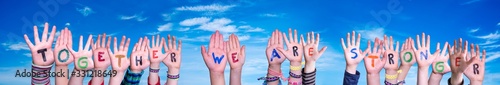 Children Hands Building Colorful Word Together We Are Stronger. Blue Sky As Background